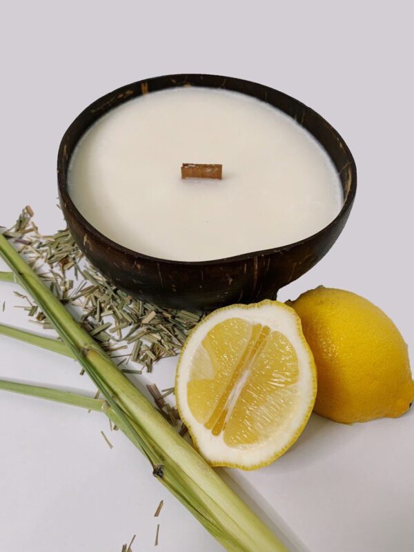 Candle in a coconut shell next to lemons