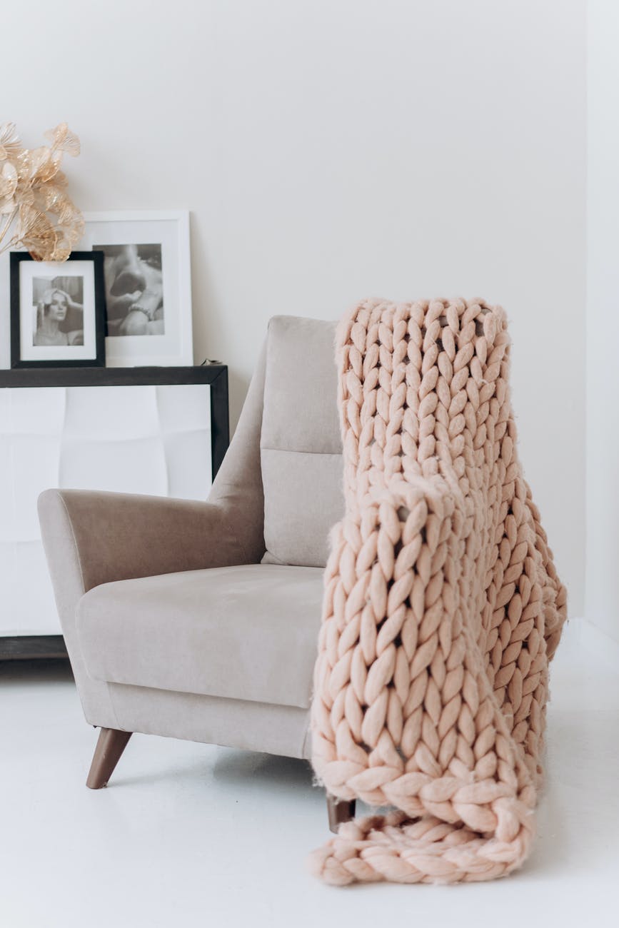 white and brown armchair beside white wall