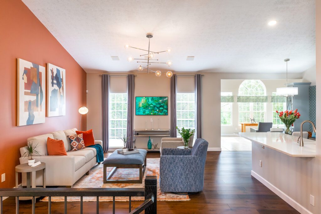 Cavern Clay living room with modern art, cream couch, and red and blue accents