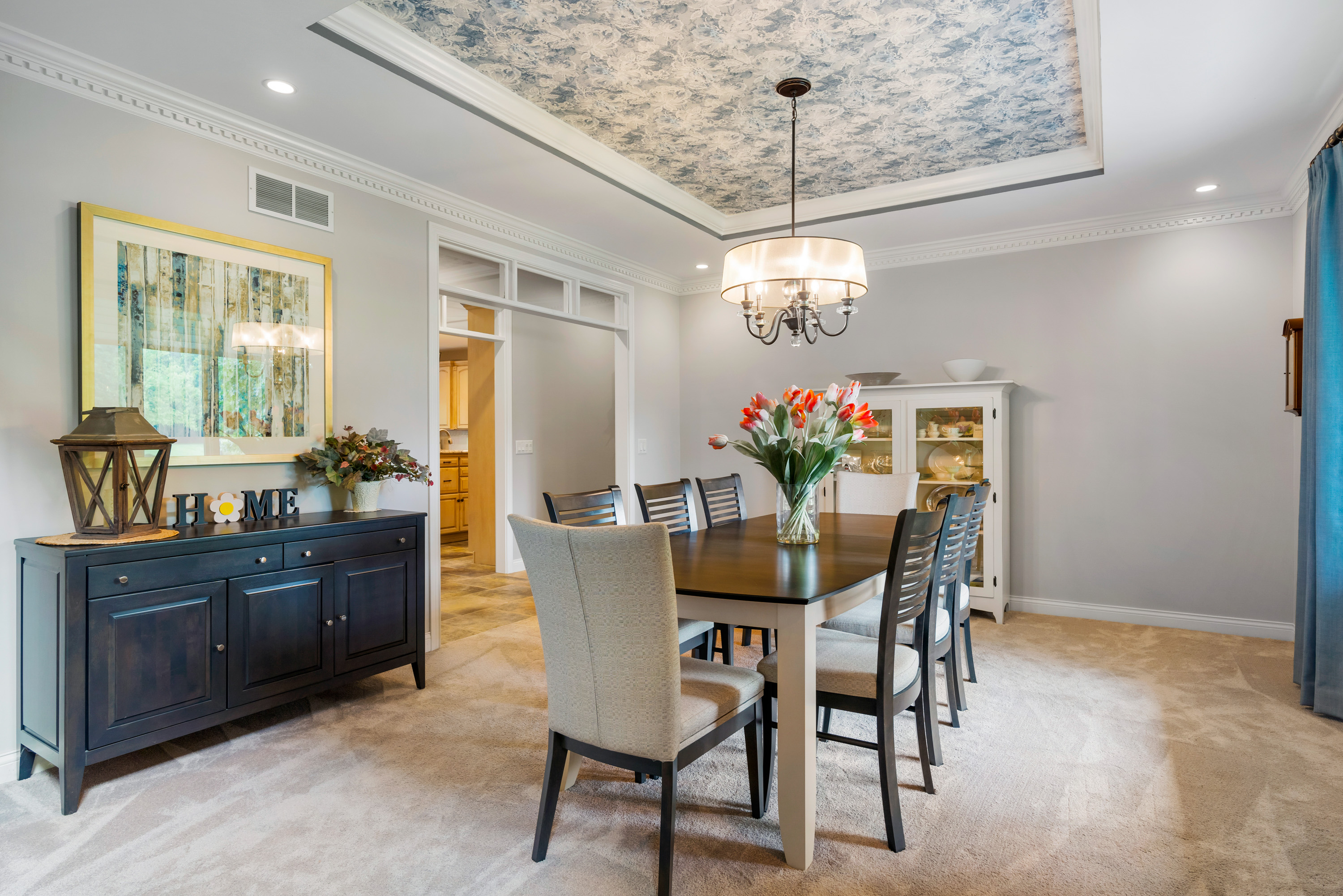 contemporary dining room with floral wallpaper ceiling and blue details