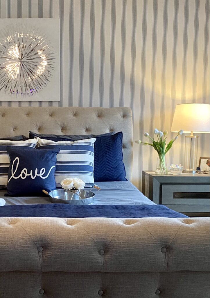 bedroom with blue accent colors and vertically striped wallpaper